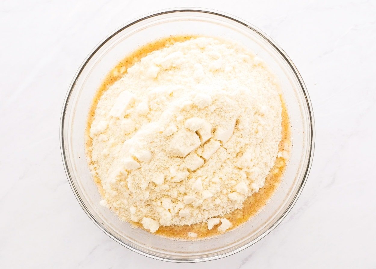 Almond flour with wet ingredients in a glass bowl.