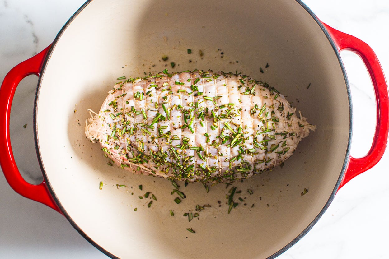 Turkey breast in large pot with rosemary.