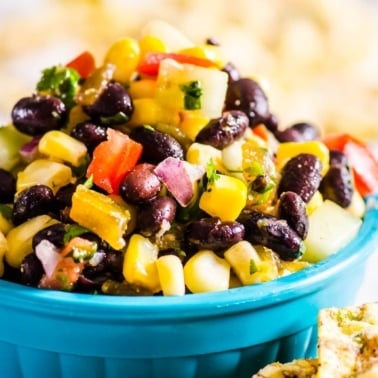 Black bean and corn salsa in a blue serving bowl with whole grain chips.