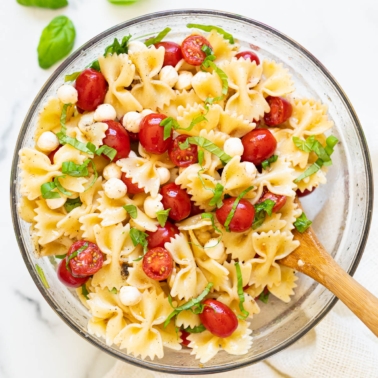 Caprese pasta salad with bocconcini, tomatoes and mozzarella served in a bowl.