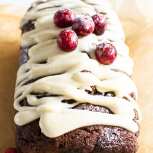 Healthy gingerbread loaf drizzled with icing and topped with cranberries.