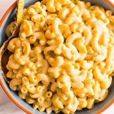 healthy mac and cheese in a blue bowl with fork