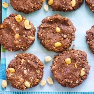 Healthy no bake protein cookies with chocolate protein powder and peanuts on parchment paper.