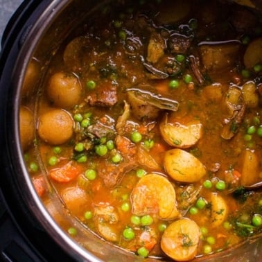 Instant pot beef stew with green peas in a pot.