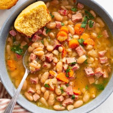 Instant pot ham and bean soup served in a bowl with cornbread muffin.