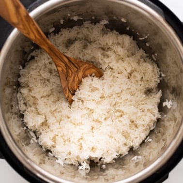 Instant pot Jasmine rice with wooden spoon in the pot.