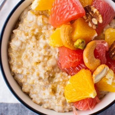 instant pot steel cut oats in a bowl with oranges and grapefruit chopped up and nuts