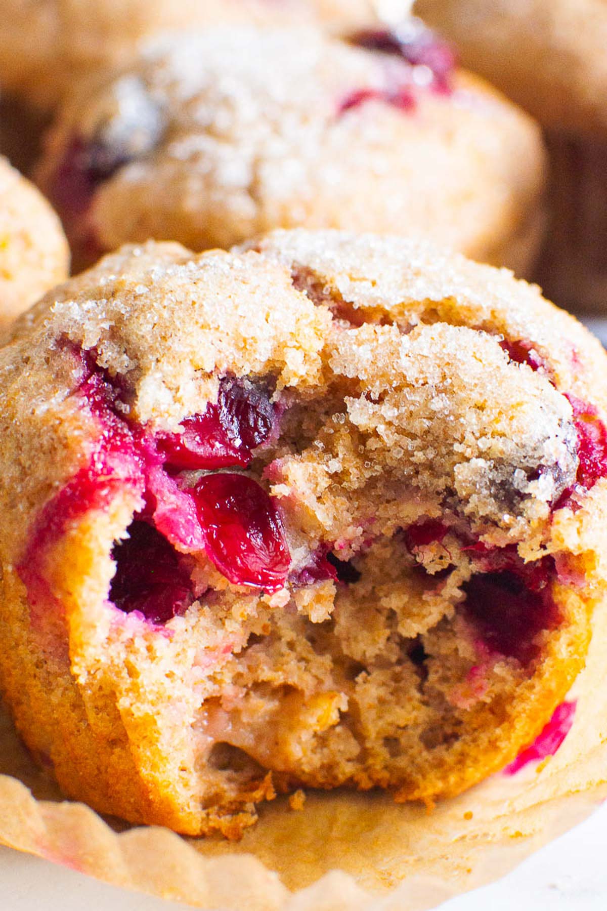 close up of healthy cranberry orange muffin with a bite taken out of