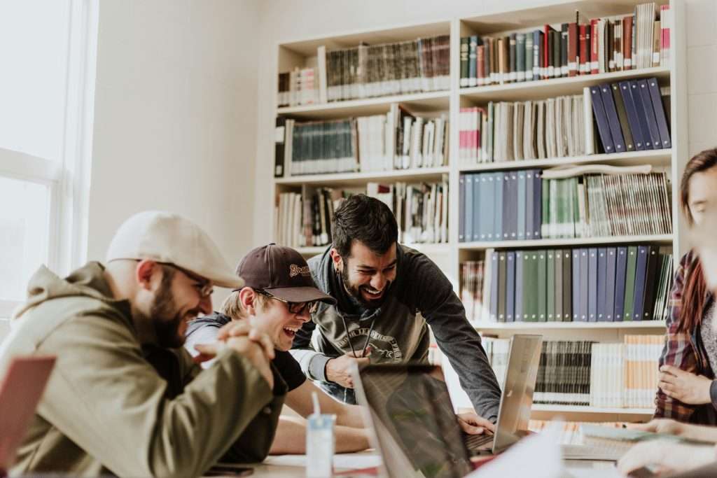 picture of people smiling while looking at a computer while participating in a team building event