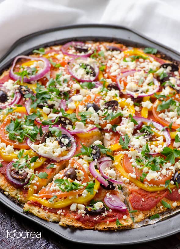 Mediterranean cauliflower pizza with bell peppers, olives, red onion and feta cheese.