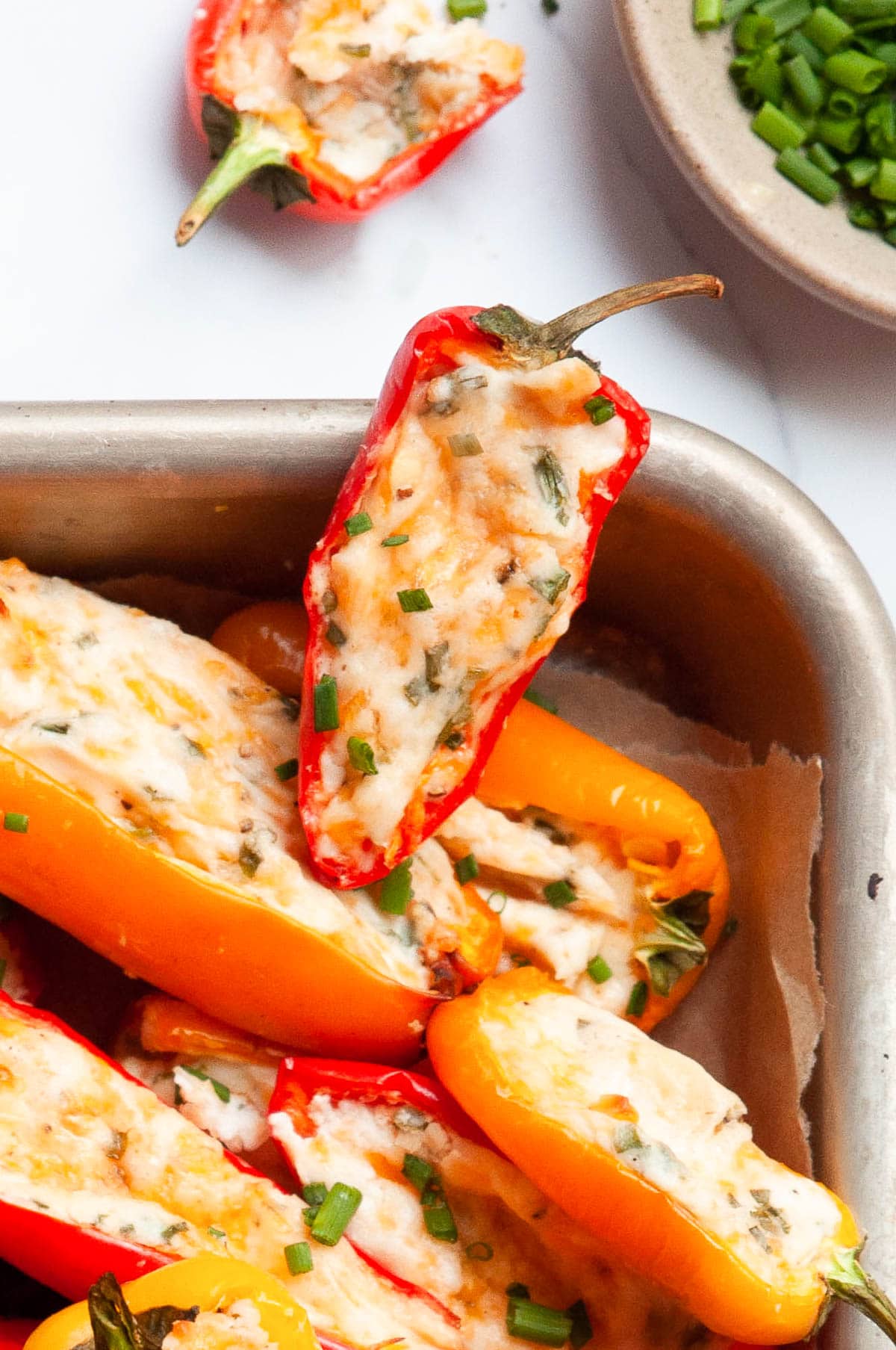 One stuffed mini pepper on a tray with other mini appetizers.