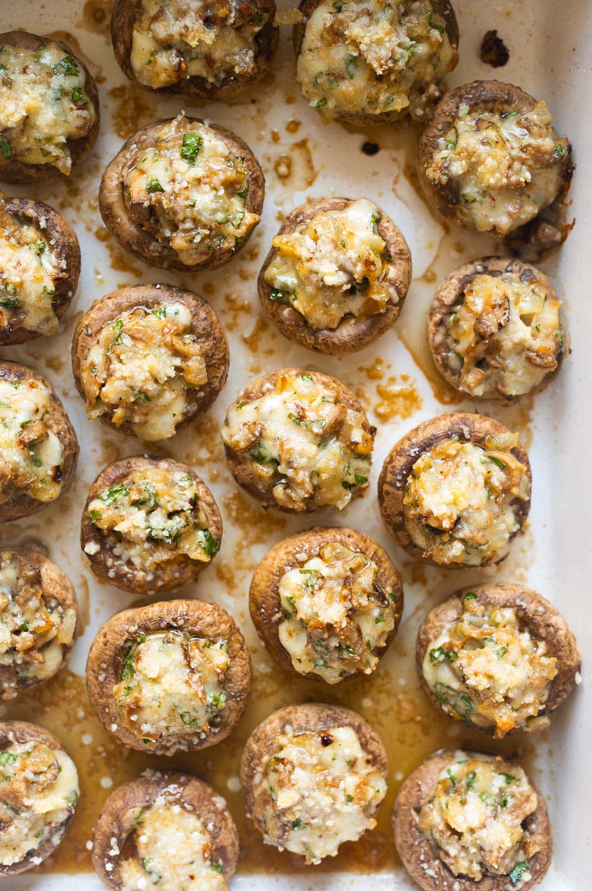 Close up off stuffed mushrooms with Parmesan cheese, parsley and mozzarella.